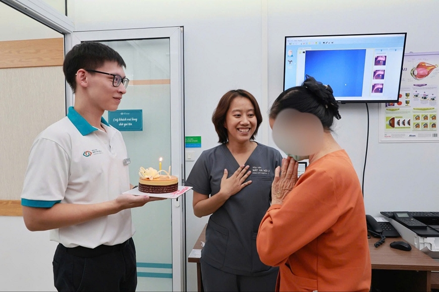 Bệnh nhân ghép giác mạc được nhân viên y tế Ngân hàng Mô của Bệnh viện Mắt Hà Nội 2 tặng bánh sinh nhật. Ảnh: ĐỨC TÂM 